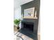 Modern black fireplace with a light wooden mantel and decorative accents at 2020 Piper Dr, Charleston, SC 29407
