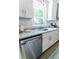 Bright kitchen featuring stainless steel appliances, granite countertops, white cabinets, and a view of the backyard at 2020 Piper Dr, Charleston, SC 29407