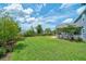 Well-manicured backyard with a large lawn, mature trees, and a charming garden at 2024 Lanneau Ln, Johns Island, SC 29455