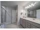 Bright bathroom featuring double vanity, large mirror, tiled shower and tile flooring at 2024 Lanneau Ln, Johns Island, SC 29455