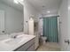 Fresh bathroom with modern vanity, toilet and shower with teal curtain at 2024 Lanneau Ln, Johns Island, SC 29455