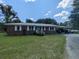 Charming red brick single-story home featuring a metal roof, carport, and well-maintained landscaping at 205 Indian Field Cir, Saint George, SC 29477