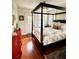 Bedroom with a four-poster bed, red chest of drawers, hardwood floors and windows at 2066 Wappoo Dr, Charleston, SC 29412