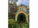 Exterior shot of home featuring a charming arched entryway and lush landscaping at 2066 Wappoo Dr, Charleston, SC 29412