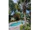 A backyard pool is surrounded by a brick patio, tropical foliage, and mature trees at 2066 Wappoo Dr, Charleston, SC 29412