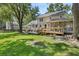 Lush backyard features a well-maintained lawn, patio area, wooden deck, and mature trees at 207 Littlejohn St, Summerville, SC 29483