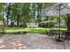 Brick patio with umbrella-covered table and chairs overlooking the lush backyard at 207 Littlejohn St, Summerville, SC 29483