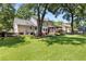 Spacious backyard showcasing a well-kept lawn, mature trees, and outdoor entertaining areas at 207 Littlejohn St, Summerville, SC 29483