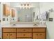 Bathroom with double sink vanity, wood cabinets, and a large mirror at 207 Littlejohn St, Summerville, SC 29483