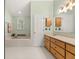 Bright bathroom featuring a soaking tub, white tile, and wood cabinetry at 207 Littlejohn St, Summerville, SC 29483