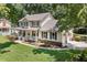 Charming two-story home featuring a spacious porch, manicured lawn, and attached garage at 207 Littlejohn St, Summerville, SC 29483