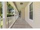 Long porch with wooden floors and white railings, providing ample space at 207 Littlejohn St, Summerville, SC 29483