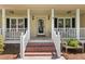 Inviting front porch with brick steps, white railings, and charming decor at 207 Littlejohn St, Summerville, SC 29483