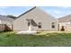 A view of the home's siding, back door, and small patio in a grass-covered backyard at 210 Wildberry Ln, Goose Creek, SC 29445
