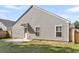A view of the home's siding, back door, and small patio in a grass-covered backyard at 210 Wildberry Ln, Goose Creek, SC 29445