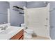 Blue bathroom with decorative shelving, tiled floors, tub and sink at 210 Wildberry Ln, Goose Creek, SC 29445