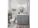 Well-lit bathroom featuring a gray vanity, round mirror, updated lighting fixtures, and neutral wall color at 216 Freeman St, Mount Pleasant, SC 29464
