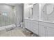 Modern bathroom featuring dual sinks, a walk-in shower with glass enclosure, and neutral tile flooring at 216 Freeman St, Mount Pleasant, SC 29464