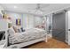 Bright bedroom with hardwood floors, a ceiling fan, a window with shutters, and an attached bathroom with sliding door at 216 Freeman St, Mount Pleasant, SC 29464