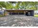 A covered carport with a paver driveway offers ample parking shaded by mature trees at 216 Freeman St, Mount Pleasant, SC 29464