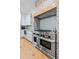 Kitchen features a stainless steel stove, brick accent wall, light blue subway tile backsplash, and hardwood flooring at 216 Freeman St, Mount Pleasant, SC 29464