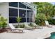 Relaxing pool area features lounge chairs and lush greenery with screened in porch in the background at 216 Freeman St, Mount Pleasant, SC 29464