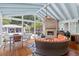 Enclosed sunroom with outdoor kitchen, fireplace, and dining with view of the backyard pool and deck at 216 Freeman St, Mount Pleasant, SC 29464