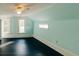 Well-lit bedroom with light blue walls, dark wood floors, two windows, and a ceiling fan at 21877 Lowcountry Hwy, Ruffin, SC 29475
