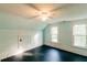 Bright bedroom featuring two windows, a ceiling fan, light blue walls, and black painted floors at 21877 Lowcountry Hwy, Ruffin, SC 29475