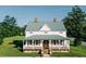 Charming home featuring a metal roof, inviting front porch, and a lush green lawn at 21877 Lowcountry Hwy, Ruffin, SC 29475