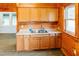 Well-lit kitchen includes wooden cabinets, ample counter space, and a double sink at 21877 Lowcountry Hwy, Ruffin, SC 29475