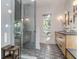 Bright bathroom with a glass shower, wooden bench, and double sink vanity at 2414 Goldbug Ave, Sullivans Island, SC 29482