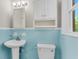 Cozy blue bathroom featuring a pedestal sink, medicine cabinet, and toilet at 245 Clarine Dr, Goose Creek, SC 29445