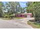 Quaint brick home featuring a garage and driveway surrounded by mature trees and landscaping at 245 Clarine Dr, Goose Creek, SC 29445