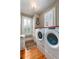 Well-lit laundry room with modern washer and dryer, storage, and hardwood floors at 2705 Parkers Landing Rd, Mount Pleasant, SC 29466