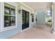 Charming front porch features a swing, black double doors, exterior lights, and decorative architectural details at 3028 River Vista Drive Way, Mount Pleasant, SC 29466