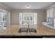 Granite kitchen island features stainless steel sink and views into the breakfast nook at 3028 River Vista Drive Way, Mount Pleasant, SC 29466
