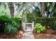 Charming backyard gate surrounded by lush, mature palm trees and landscaping at 31 Seagrass Ln, Isle of Palms, SC 29451
