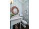 Stylish powder room with a unique mirror, decorative wallpaper, and modern fixtures at 31 Seagrass Ln, Isle of Palms, SC 29451