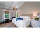 Calm and inviting bedroom with large windows, dark hardwood floors and a chandelier at 31 Seagrass Ln, Isle of Palms, SC 29451