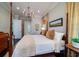 Elegant bedroom with four-poster bed, chandelier, and natural light at 31 Seagrass Ln, Isle of Palms, SC 29451