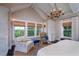 A spacious bedroom offers plenty of natural light with large windows and an eye-catching chandelier at 31 Seagrass Ln, Isle of Palms, SC 29451