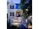 Charming two-story home with a welcoming front porch, illuminated stairs and meticulously landscaped yard at 31 Seagrass Ln, Isle of Palms, SC 29451