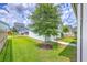 View of the backyard showing green grass, a tree and a small white door at 312 Cypress Knee Landing, Summerville, SC 29483