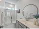 Modern bathroom with a glass-enclosed shower, grey vanity, a large round mirror, and marble floors at 312 Cypress Knee Landing, Summerville, SC 29483