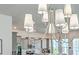 Close up of chandelier with kitchen featuring stainless steel appliances and gray cabinets in the background at 312 Cypress Knee Landing, Summerville, SC 29483
