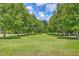A large, grassy common area is lined with trees at 312 Cypress Knee Landing, Summerville, SC 29483