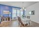 Bright dining room with hardwood floors, a chandelier, and a blue accent wall for modern elegance at 312 Cypress Knee Landing, Summerville, SC 29483