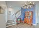 Bright foyer featuring hardwood floors, staircase, wooden bench, and a wooden hutch, and blue accent wall at 312 Cypress Knee Landing, Summerville, SC 29483