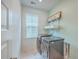 Laundry room featuring side-by-side washer and dryer with overhead storage shelves, with marble style floor tile at 312 Cypress Knee Landing, Summerville, SC 29483